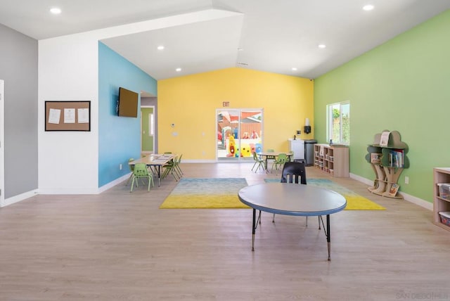 playroom with light wood-type flooring and lofted ceiling