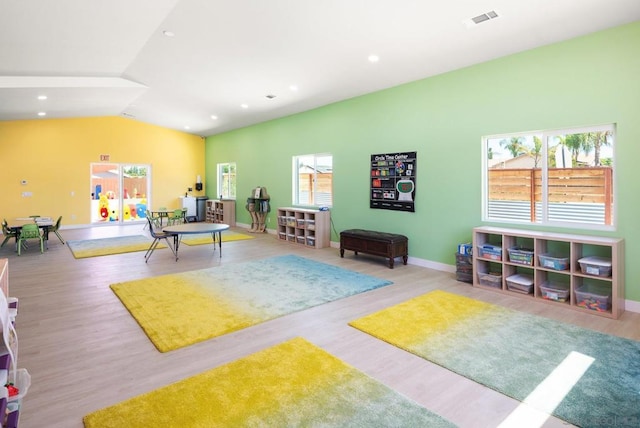 playroom featuring lofted ceiling and light hardwood / wood-style floors