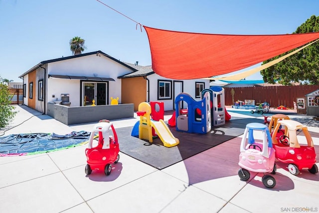 view of playground featuring a patio