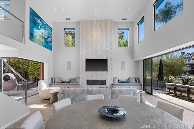 dining area with a high ceiling, visible vents, and wood finished floors