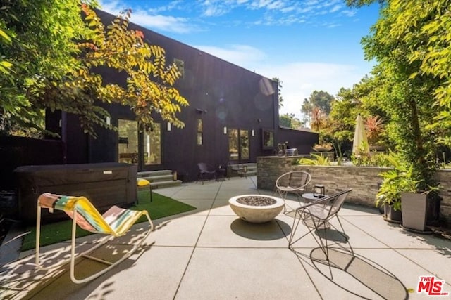 view of patio featuring an outdoor fire pit and a hot tub