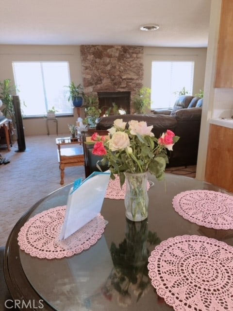 dining room with a stone fireplace and carpet