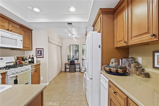 kitchen with white appliances, crown molding, light tile patterned floors, and a tray ceiling