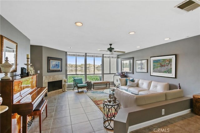 living room featuring ceiling fan, light tile patterned floors, and a fireplace