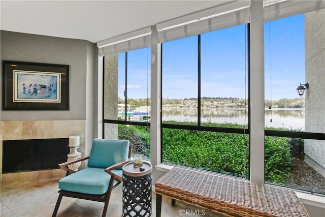 sunroom / solarium featuring a fireplace, a water view, and a wealth of natural light