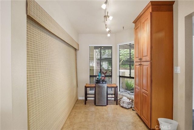 hallway with light tile patterned floors and rail lighting