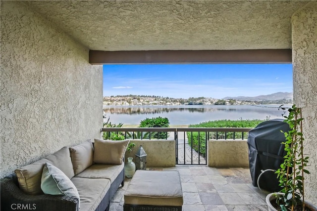 balcony with area for grilling and a water and mountain view