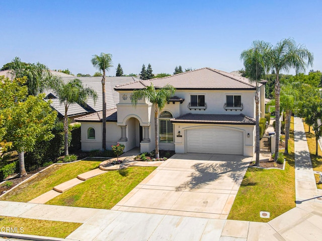 mediterranean / spanish-style house with stucco siding, concrete driveway, a tile roof, and a front lawn