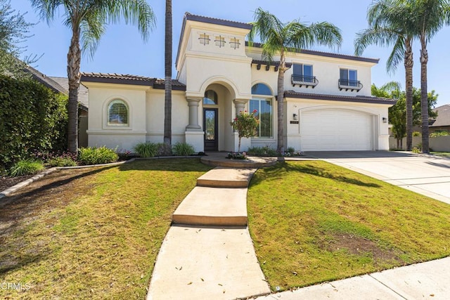 mediterranean / spanish-style home featuring a tile roof, a front yard, stucco siding, driveway, and an attached garage