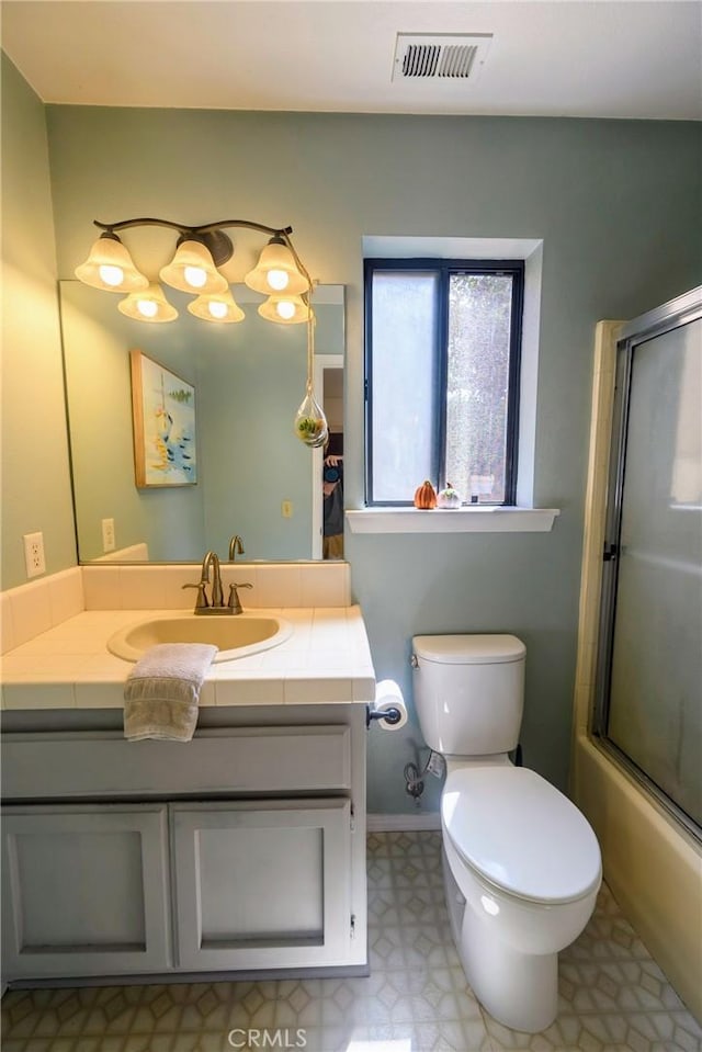 full bathroom featuring shower / bath combination with glass door, vanity, and toilet