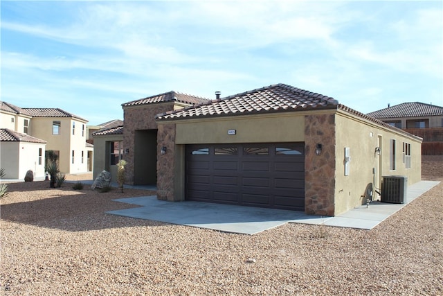 mediterranean / spanish-style house featuring a garage and central AC