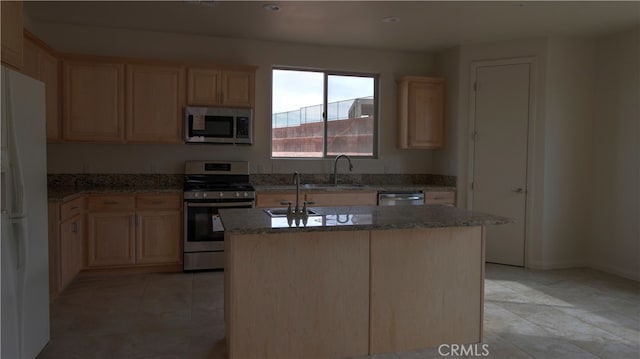 kitchen with stainless steel appliances, light brown cabinets, a center island, and sink