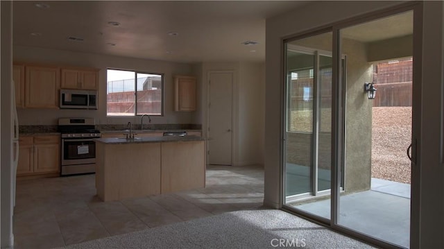 56925 Hidden Gold Ct, Yucca Valley, CA 92284 - kitchen with stainless steel appliances, light brown cabinets, an island with sink, and light tile patterned floors