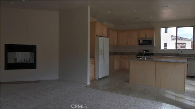 56925 Hidden Gold Ct, Yucca Valley, CA 92284 - kitchen featuring appliances with stainless steel finishes, a center island with sink, light brown cabinetry, open floor plan, and light colored carpet