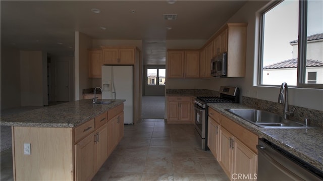 kitchen featuring appliances with stainless steel finishes, light brown cabinets, and sink