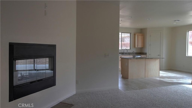 56925 Hidden Gold Ct, Yucca Valley, CA 92284 - kitchen with light brown cabinets, a kitchen island, and light carpet