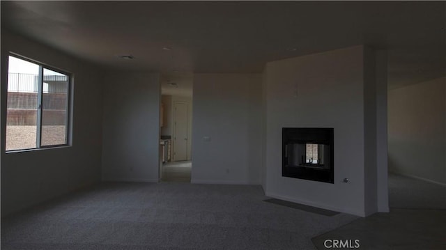 56925 Hidden Gold Ct, Yucca Valley, CA 92284 - unfurnished living room featuring carpet and a multi sided fireplace