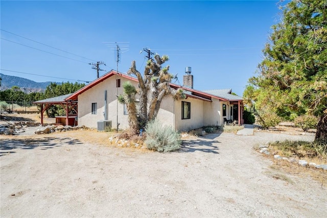 view of home's exterior with a mountain view and central AC unit