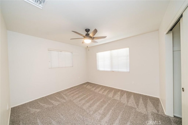 empty room featuring ceiling fan and carpet floors