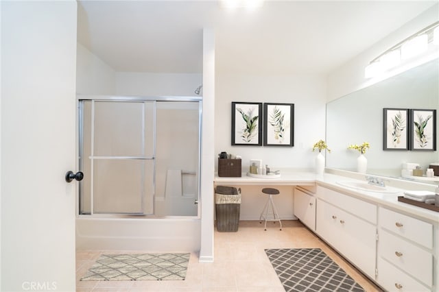 bathroom featuring tile patterned flooring, vanity, and bath / shower combo with glass door