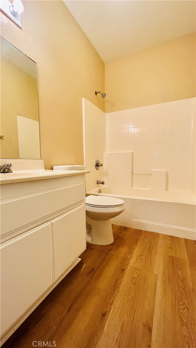 full bathroom with shower / washtub combination, hardwood / wood-style floors, vanity, and toilet