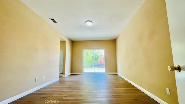 unfurnished room with hardwood / wood-style flooring