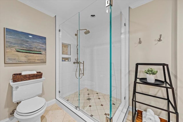 bathroom featuring crown molding, toilet, a shower with shower door, and tile patterned flooring