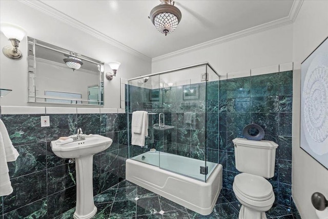 bathroom with crown molding, tile walls, bath / shower combo with glass door, and toilet