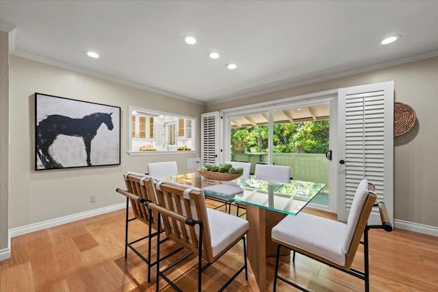 dining room with crown molding and light wood-type flooring