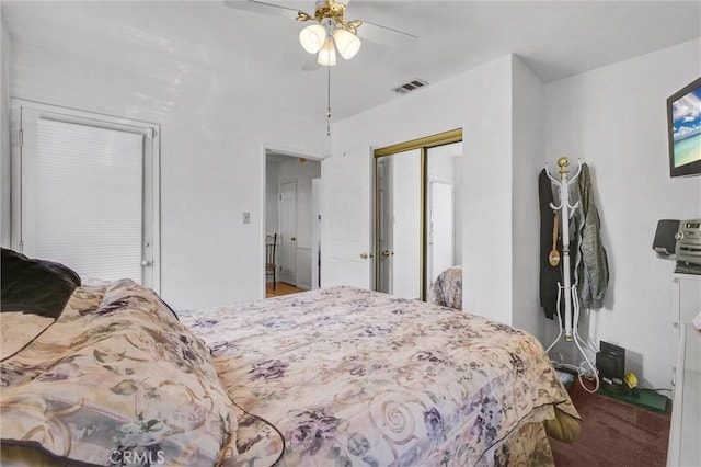 carpeted bedroom with ceiling fan and a closet