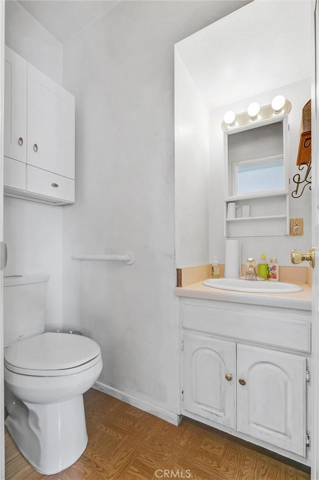 bathroom with hardwood / wood-style floors, vanity, and toilet