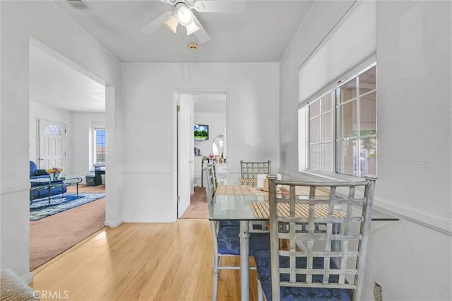 dining space with ceiling fan and hardwood / wood-style floors