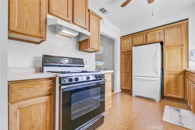 kitchen with ceiling fan, white refrigerator, black gas stove, and light wood-type flooring