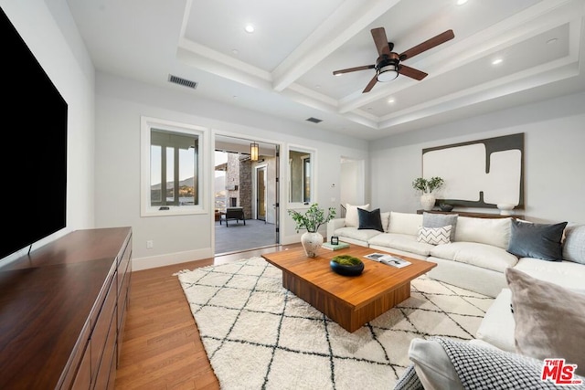 living room featuring light hardwood / wood-style floors, beam ceiling, and ceiling fan