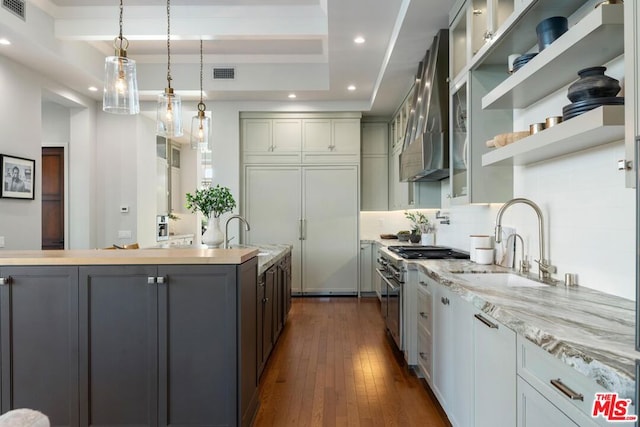 kitchen featuring gray cabinetry, wall chimney exhaust hood, dark hardwood / wood-style floors, sink, and stainless steel range