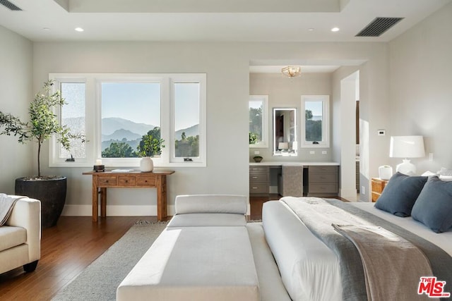 bedroom with dark hardwood / wood-style flooring and a mountain view