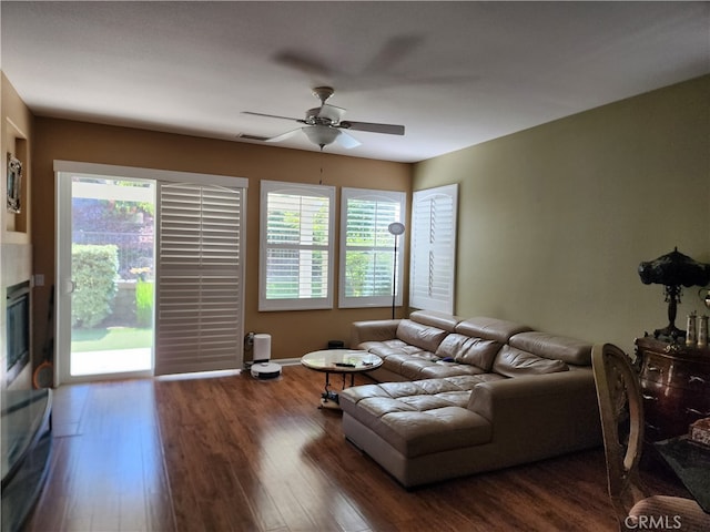 living room featuring ceiling fan and dark wood-type flooring