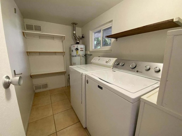 laundry area with light tile patterned floors, separate washer and dryer, and secured water heater