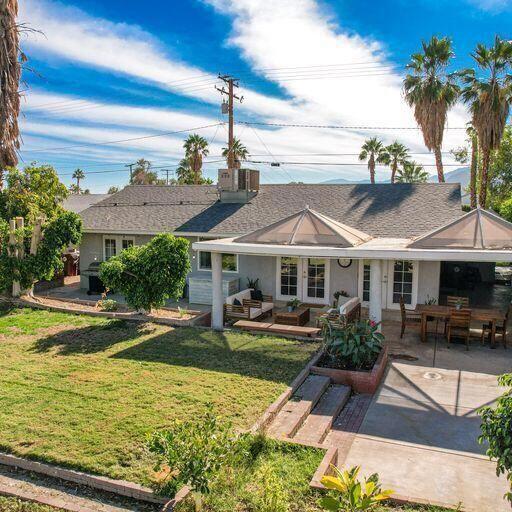 back of house featuring a lawn and a patio