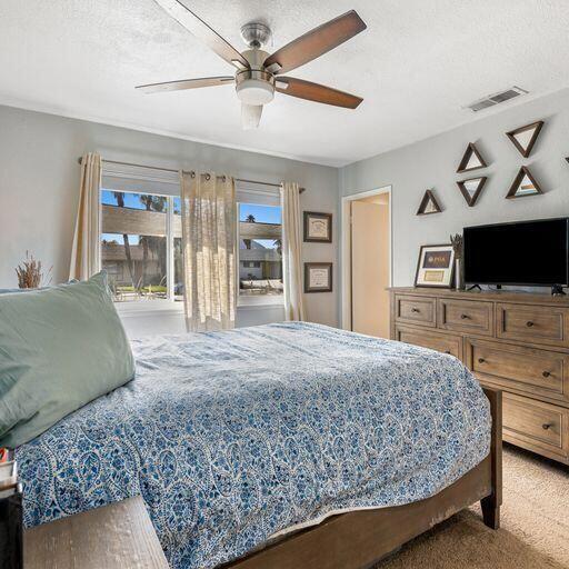 carpeted bedroom with a textured ceiling and ceiling fan