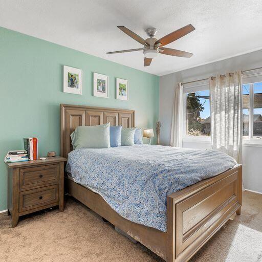 bedroom featuring light carpet and ceiling fan