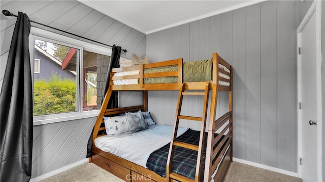 bedroom featuring carpet floors and wooden walls