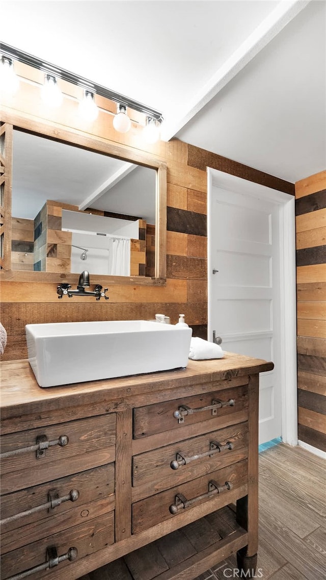 bathroom featuring wood walls, vanity, and hardwood / wood-style flooring