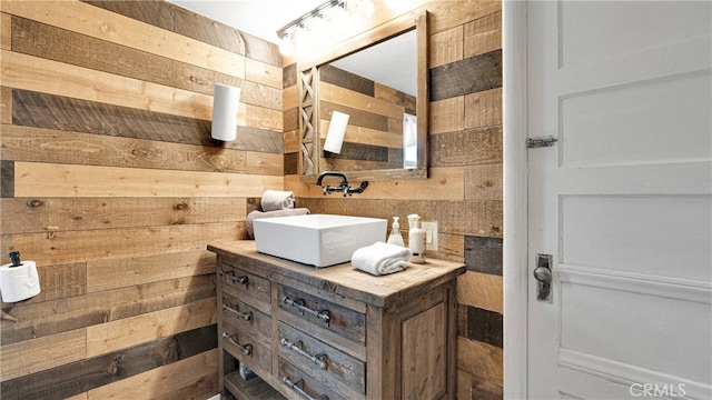 bathroom with vanity and wood walls