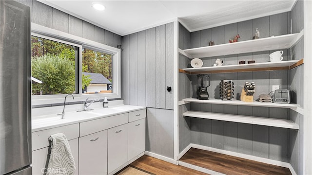 interior space featuring vanity, wood walls, and hardwood / wood-style floors