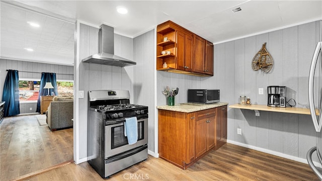 kitchen featuring crown molding, wall chimney range hood, stainless steel appliances, and hardwood / wood-style flooring