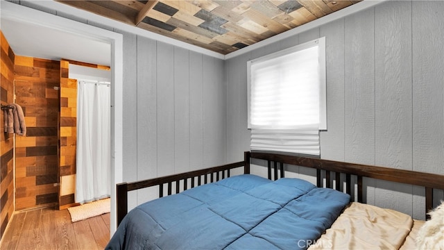 bedroom featuring wooden walls and hardwood / wood-style floors