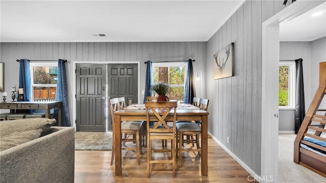 dining room with wooden walls and hardwood / wood-style flooring