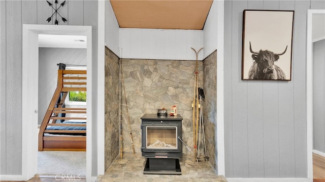 interior details with wood walls and a wood stove