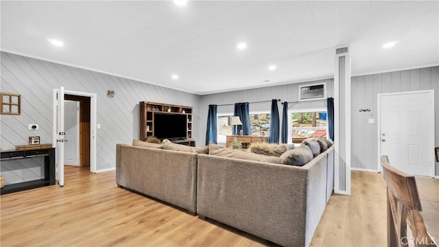 living room featuring ornamental molding, wood walls, and light hardwood / wood-style floors